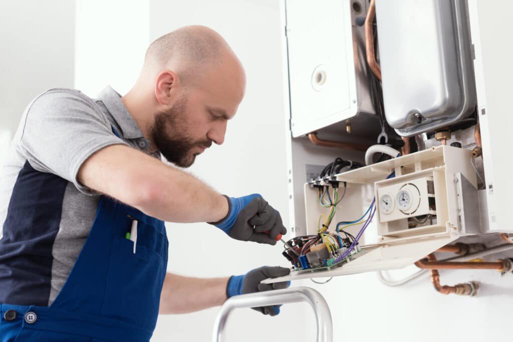 Technician servicing a natural gas boiler at home